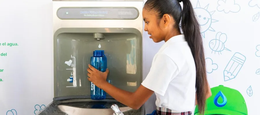 Student fills a reusable bottle at a SEAPAL school drinking-water station.