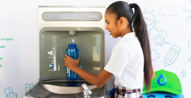 Student fills a reusable bottle at a SEAPAL school drinking-water station.