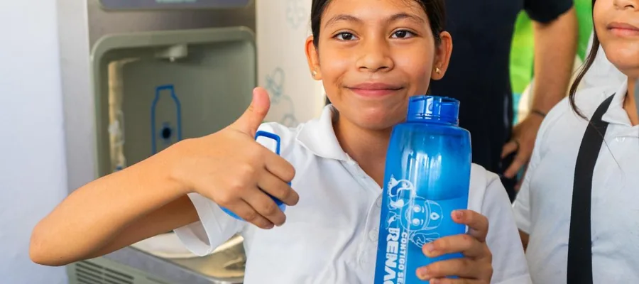 A student holds a reusable water bottle beside the new drinking fountain at Cuauhtémoc Elementary School.