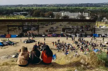 Migrants gathered near a border barrier